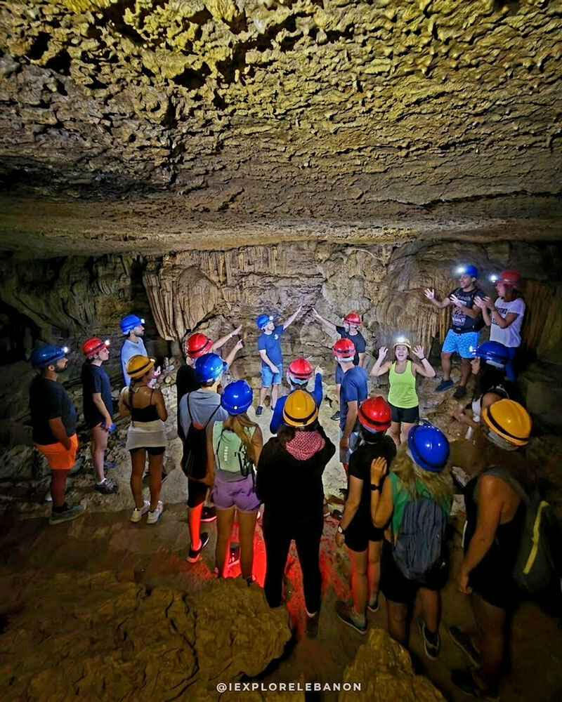 Guided caving experience exploring an underground cave in Lebanon with helmets and expert equipment