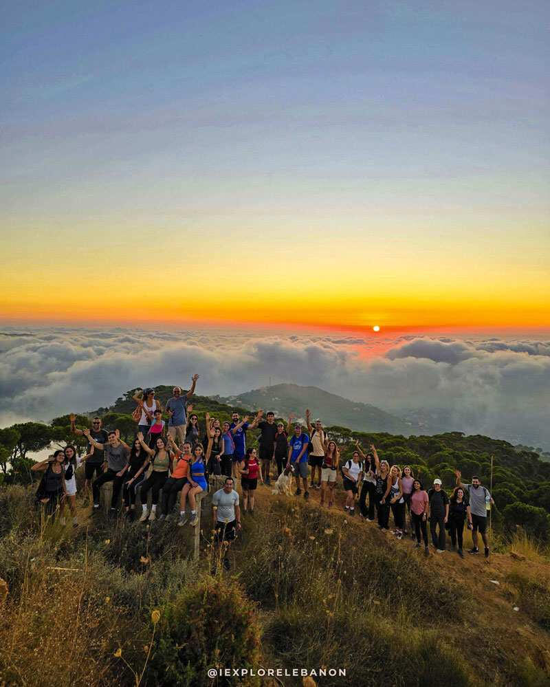 Large hiking group watching a sunset above the clouds in the Lebanon mountains during a guided night hike